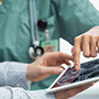 Female doctor nurse reviewing brain scan digital tablet